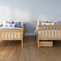 Two wooden twin beds with blue-and-white coastal bedding in a bright minimalist kids bedroom with hardwood floor