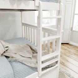 White wooden bunk bed with light blue bedding and plaid blanket in a bright bedroom.