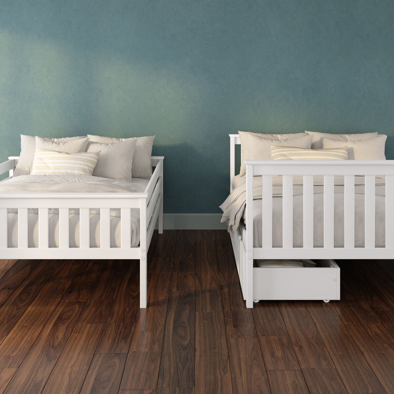 Modern bedroom interior with two white wooden twin beds, neutral beige bedding and striped accent pillows against a teal textured accent wall and dark hardwood flooring