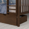 Close-up of dark walnut wood bunk bed with guard rails and under-bed storage drawer, blue quilted bedding and textured neutral rug