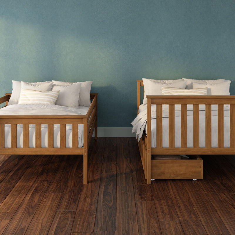 Two wooden twin beds with white bedding and striped pillows against a teal textured accent wall on dark hardwood floors, cozy modern farmhouse bedroom