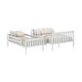 White wooden twin daybed with pull-out trundle, slatted headboard and footboard, neutral linen bedding and striped accent pillows