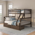 Dark wood bunk bed with ladder and built-in storage drawers, blue and white bedding and floral pillows in a bright coastal-style bedroom
