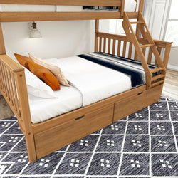 Wooden bunk bed with storage drawers and ladder, white bedding, orange accents, in a modern bedroom setting with patterned carpet.
