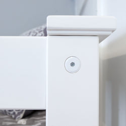 Close-up of a white wooden bed frame corner with assembly bolt, highlighting sturdy construction.