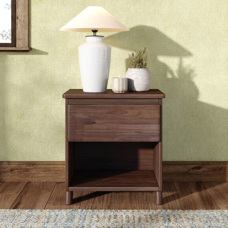 Wooden nightstand with white ceramic table lamp, two decorative vases and candle against a pale green textured wall