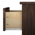 Open wooden drawer with dovetail joints in dark wood cabinet.