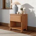 Wooden bedside table with gray ceramic lamp, beige shade and two textured pots holding a small green plant