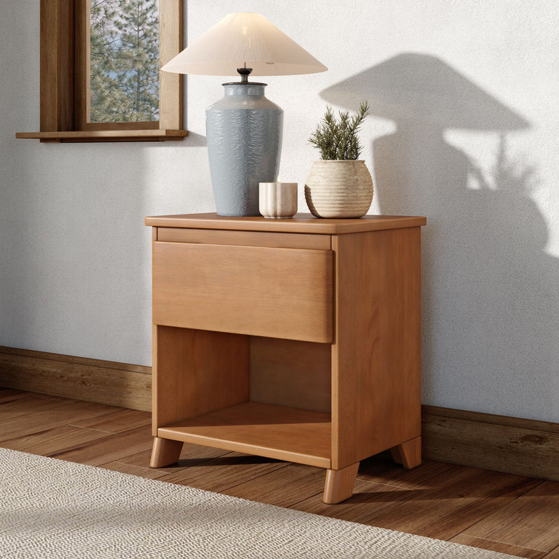 Wooden bedside table with gray ceramic lamp, beige shade and two textured pots holding a small green plant