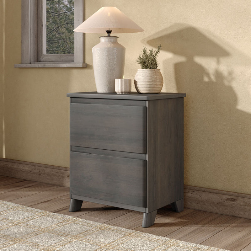 Cozy neutral bedroom decor: gray wooden nightstand with white ceramic table lamp, potted plant and candle against a textured beige wall