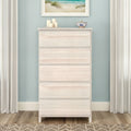 Whitewashed five-drawer wooden dresser in coastal bedroom decor with light blue wall, beach artwork, candles and ceramic bowl, vertical storage chest