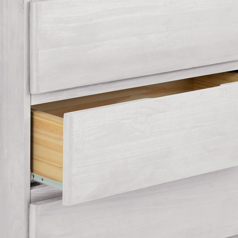 Open white wooden dresser drawer showing spacious interior for storage.