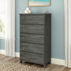 Tall gray wooden five-drawer dresser with tapered legs in light-blue bedroom, modern bedroom storage chest