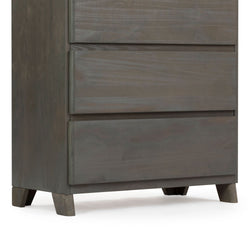 Dark wooden dresser with three drawers and short legs.
