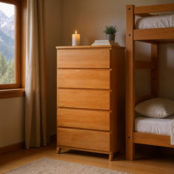 Cozy bedroom with wooden furniture, chest of drawers, and bunk bed by window with mountain view, candle and plant for decoration.