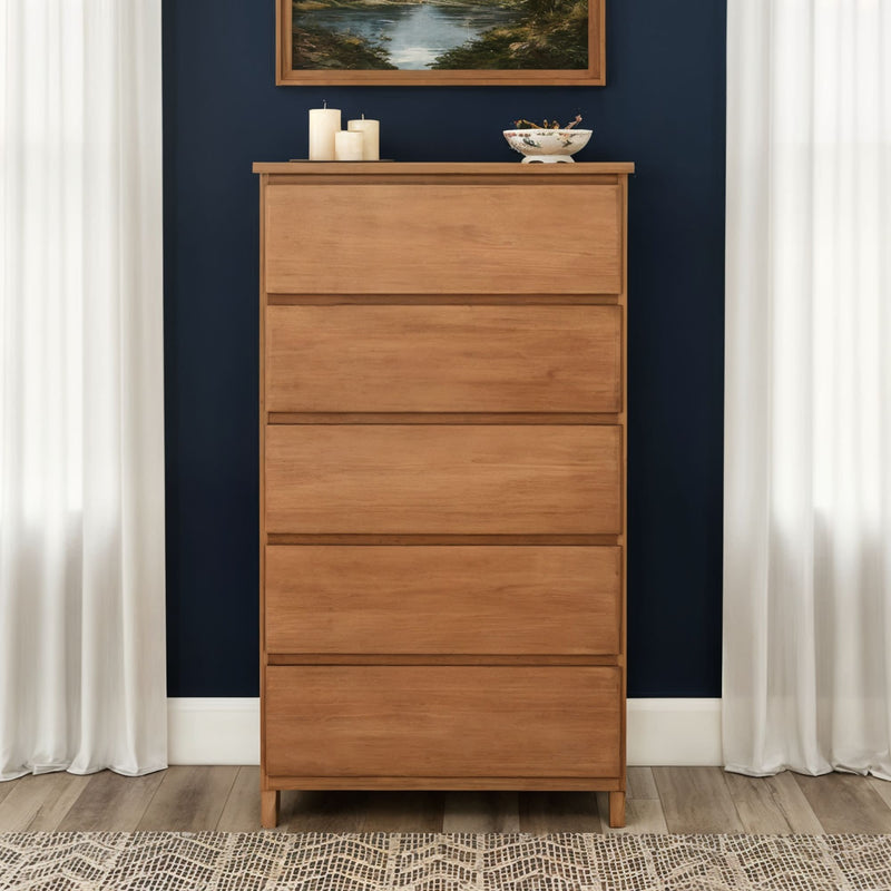 Mid-century modern tall wooden dresser in natural oak, chest of drawers against a navy accent wall with white curtains and tabletop decor