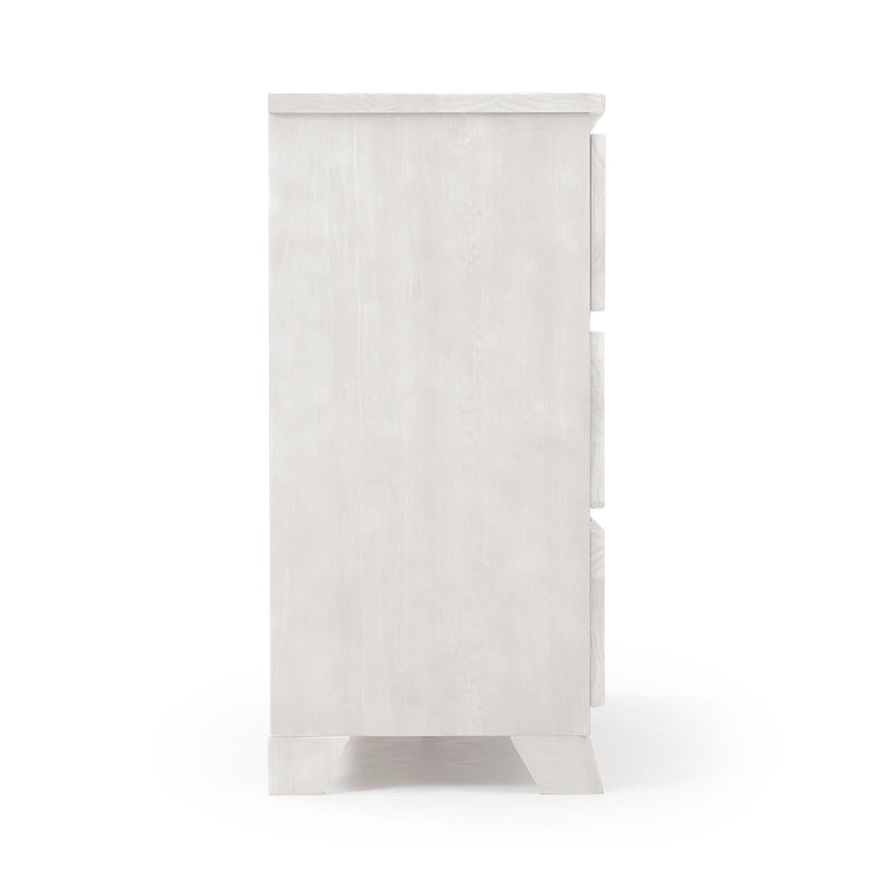 Side view of a white wooden three-drawer dresser with a whitewashed finish on a white background