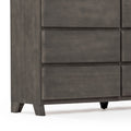 Close-up of modern gray wooden dresser corner with recessed drawer fronts, tapered legs and matte finish, contemporary bedroom storage piece