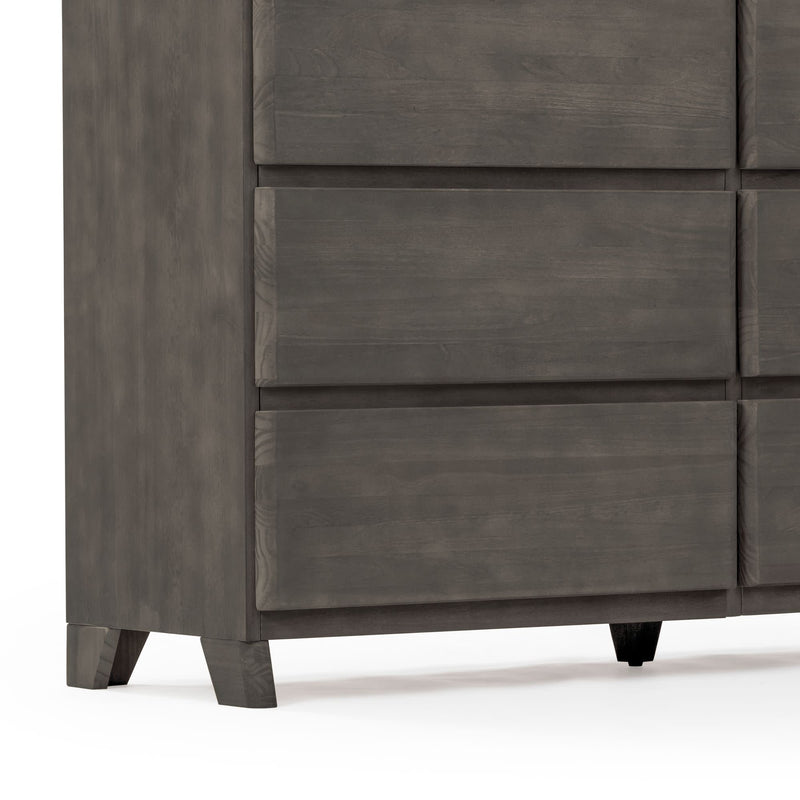 Close-up of modern gray wooden dresser corner with recessed drawer fronts, tapered legs and matte finish, contemporary bedroom storage piece