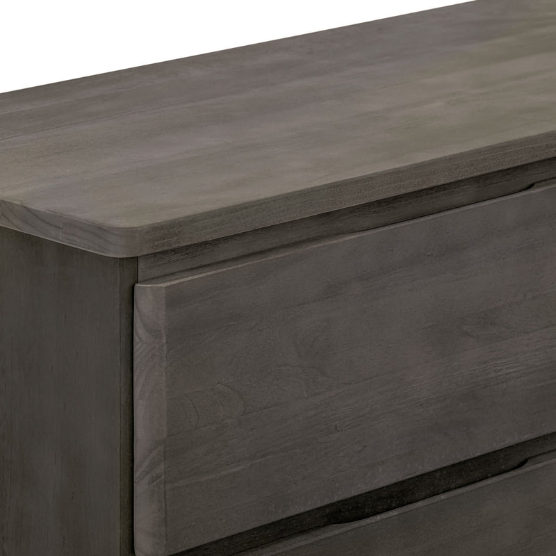 Close-up of gray wooden dresser drawer and rounded top edge showing textured wood grain — modern bedroom furniture
