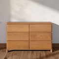 Minimalist light-wood six-drawer dresser on hardwood floor against a neutral wall, modern bedroom storage chest for small-space interiors
