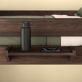Wooden bedside shelf with black bottle and smartphone, perfect for modern bedroom decor.