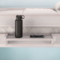 Bunk bed shelf with a black water bottle and smartphone, ideal for space-saving bedroom storage.