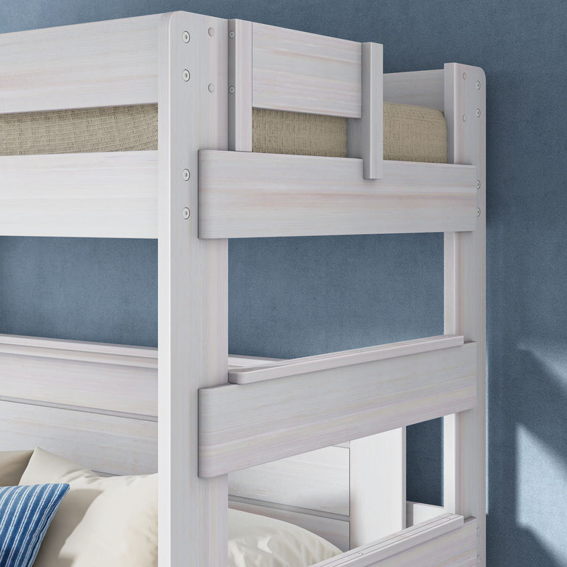 Whitewashed wooden twin-over-twin bunk bed with safety guardrails, beige mattress and blue striped pillow against a textured blue wall in a modern kids' bedroom