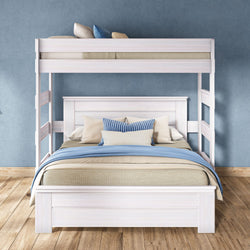 White wooden bunk bed with full-size lower bed and twin top bunk, blue and beige bedding and striped pillows on hardwood floor against a blue accent wall