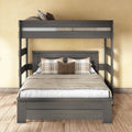 Gray solid-wood bunk bed with full-size lower bed and twin top bunk, neutral beige bedding and plaid accent pillows on wooden floor against a warm yellow wall