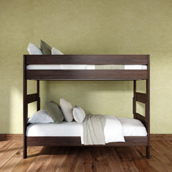 Modern dark wood bunk bed with white bedding and green accent wall on hardwood floor, space-saving bedroom furniture