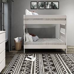 Modern bedroom with white wooden bunk bed and decorative patterned rug.