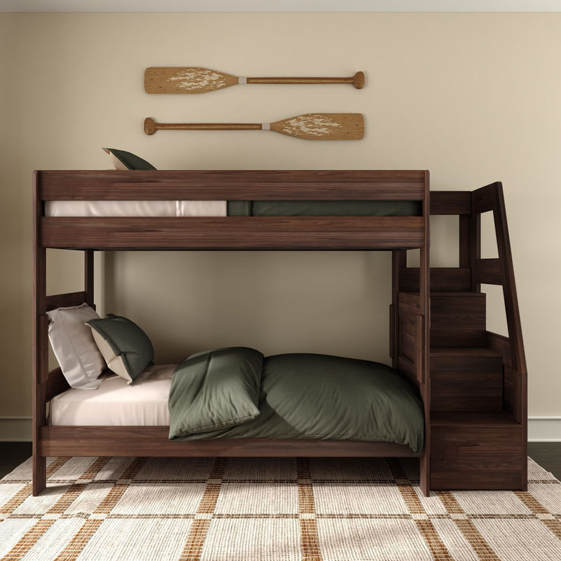 Dark walnut wooden bunk bed with built-in staircase storage, green bedding and pillows, rustic wooden oar wall decor and plaid area rug in a neutral modern kids' bedroom