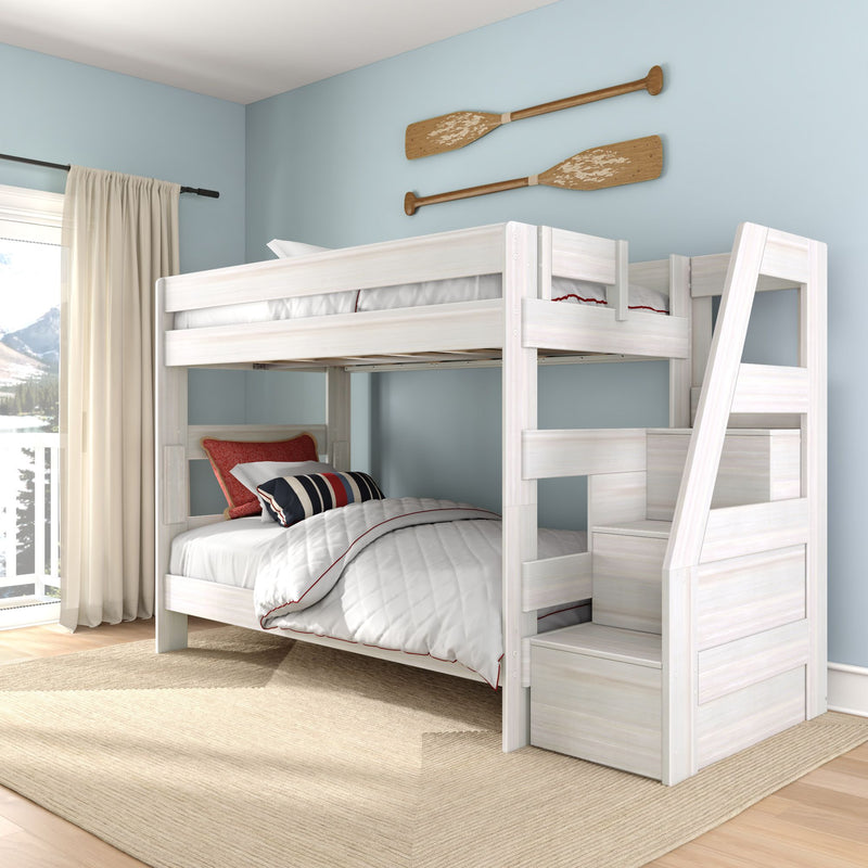 White wooden bunk bed with ladder in coastal kids bedroom, light blue walls, quilted white bedding, striped pillows and rustic wooden oars mounted above