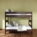 Dark walnut wooden bunk bed with white linens and neutral pillows in a minimalist bedroom with green textured wall and hardwood floor