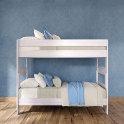 White wooden bunk bed with blue and beige bedding in a modern children's bedroom — space-saving design on hardwood floor against a textured blue wall