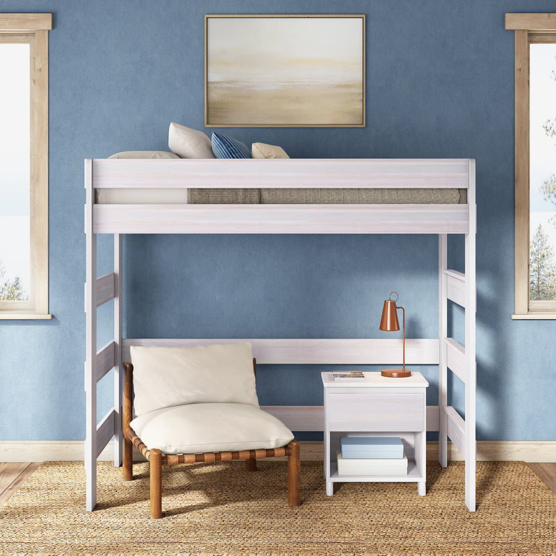 White wooden twin loft bed with mattress, cozy lounge chair and white nightstand with copper lamp against blue accent wall — modern small-space bedroom furniture and reading nook