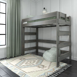 Wooden loft bed with green bedding in a modern bedroom featuring a geometric patterned rug and light green curtains.