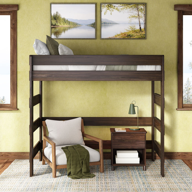 Dark wood loft bed with cozy reading nook — armchair, green throw, wooden nightstand and lamp in a modern rustic bedroom