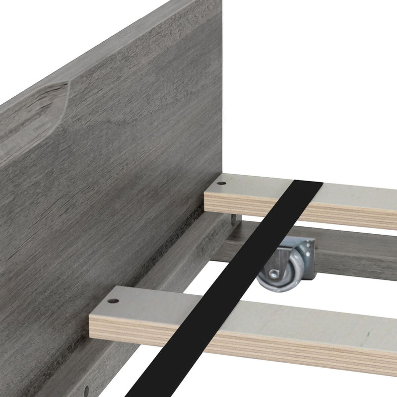Close-up of gray wood platform bed frame with plywood slats, black center support strap and metal caster wheel for added center support