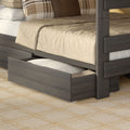 Gray wooden trundle bed with beige bedding and plaid accent pillows, open under-bed storage drawer for small bedrooms
