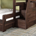 Dark walnut solid wood bunk bed with built-in staircase storage drawers, guardrail and white mattress on patterned rug in modern kids' bedroom