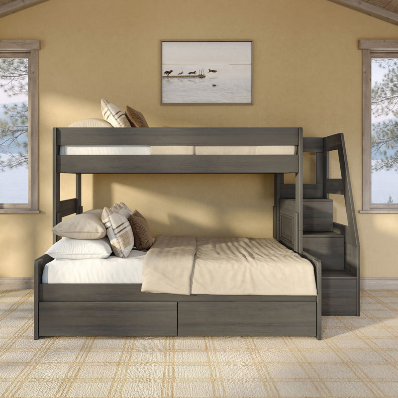 Gray wooden bunk bed with built-in storage drawers and staircase in a neutral beige bedroom, layered pillows, plaid rug, framed lake print, and windowed pine views
