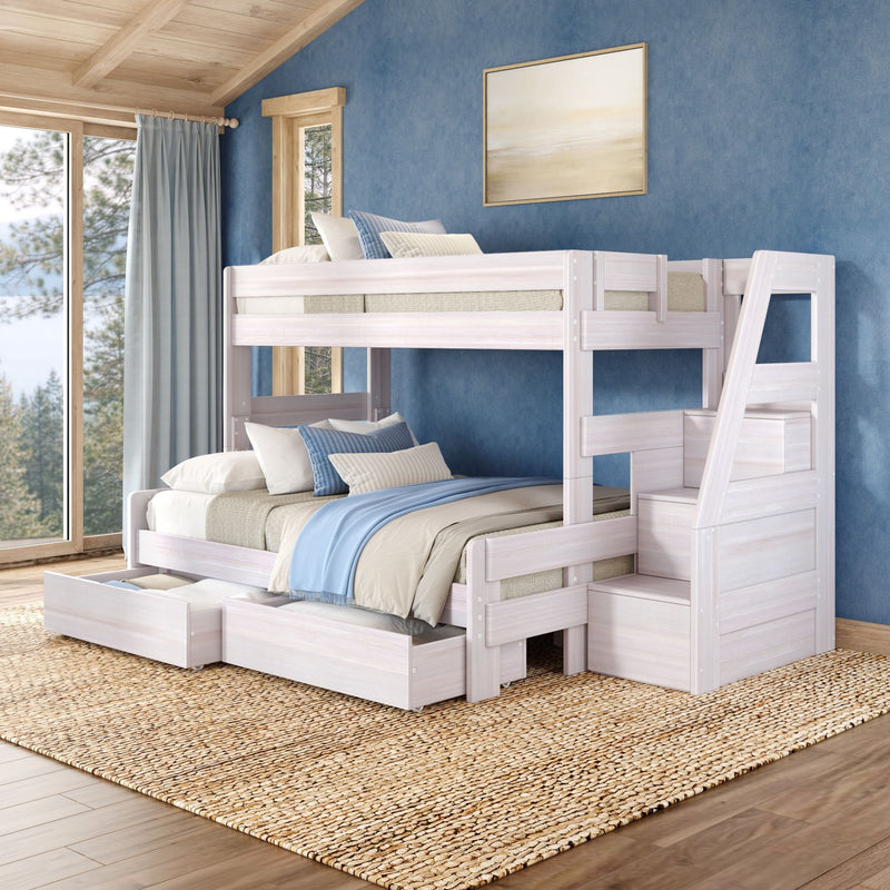 Whitewashed wooden bunk bed with staircase and trundle in coastal bedroom featuring blue textured wall, blue-striped bedding, woven jute rug and large windows with lake and pine tree view
