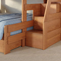Close-up of solid wood bunk bed with built-in storage stairs and drawers, natural finish, blue bedding and woven rug in a space-saving kids' bedroom