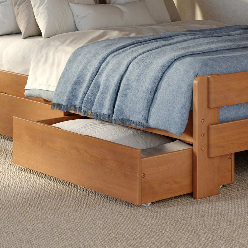 Wooden trundle bed with white bedding and pillows, light blue woven throw blanket draped over mattress, open underbed storage drawer and textured woven rug in modern bedroom