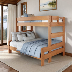 Solid wood twin-over-full bunk bed with blue bedding in a bright rustic bedroom featuring large windows and a forest view