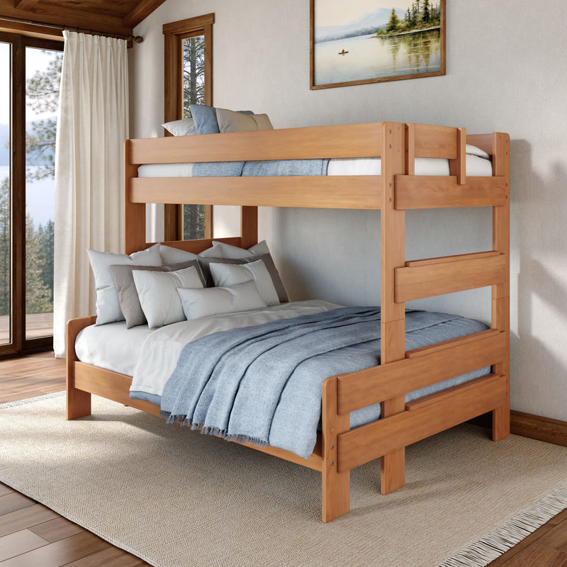 Solid wood twin-over-full bunk bed with blue bedding in a bright rustic bedroom featuring large windows and a forest view