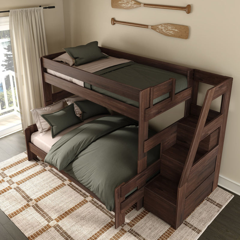 Dark walnut twin-over-full bunk bed with built-in staircase storage, green bedding and pillows, patterned area rug and coastal oar wall decor in a sunlit bedroom