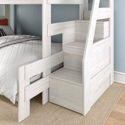 Whitewashed wooden twin-over-twin bunk bed with built-in staircase storage, pull-out drawers and safety rails in a kids' bedroom